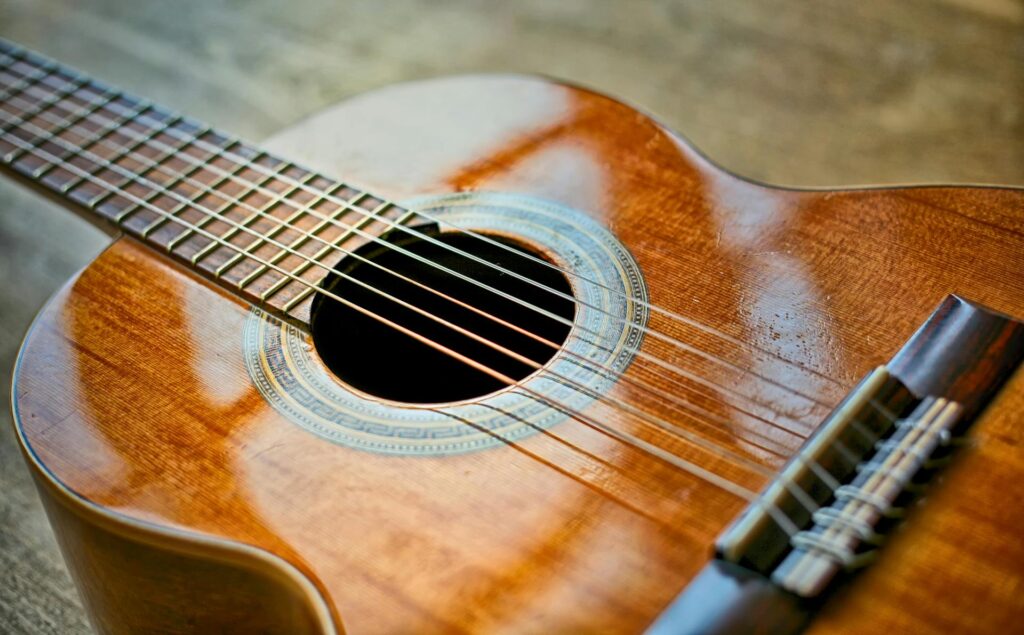 photograph of a guitar set on the ground with reflected light from windows